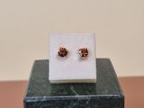 a close up of a pair of earrings sitting on top of a marble block