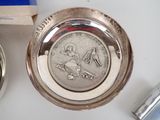 a silver plate with a coin on it next to a lighter