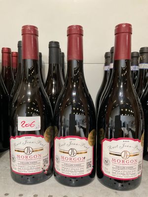 plusieurs bouteilles de vin sont alignées sur une étagère