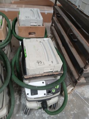 une pile d'équipements électroniques posée sur le sol à côté d'une pile de cartons