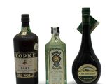 three bottles of liquor sitting next to each other on a white surface