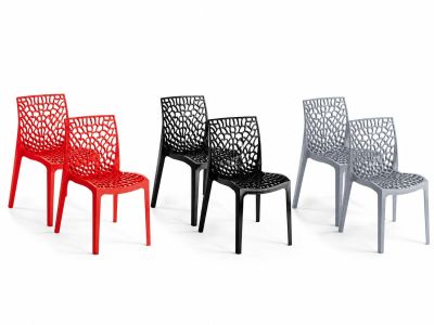 three different colored plastic chairs sitting next to each other on a white surface