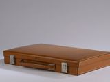 a brown leather suitcase sitting on a white surface