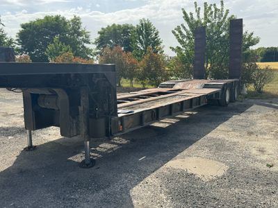 une photo d'une remorque à plateau garée sur un parking
