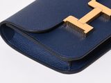 a close up of a blue purse with a gold t on it