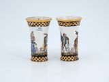 pair of porcelain vases with figures on them on a white surface