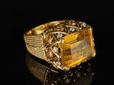 an image of a gold ring with a large citrine stone surrounded by diamonds