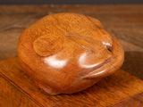 a wooden sculpture of a bear sitting on a wooden block