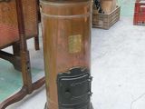 an old fashioned stove sitting on the floor in a warehouse