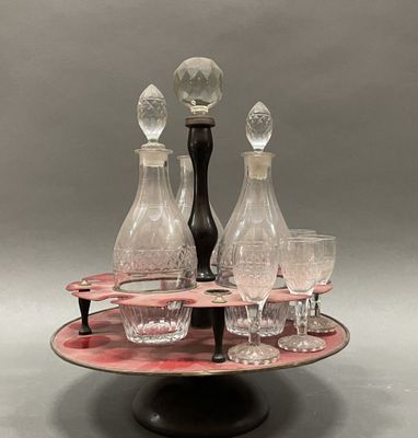 bottles and glasses on a tray with a candle holder on top of it
