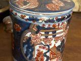 a blue and red pot with a lid sitting on a table