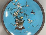 a blue plate with flowers and birds on it