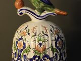 a bird sitting on top of a bell on a table