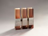 two brown and silver vases sitting next to each other on a white surface