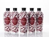 four bottles of red and white floral print on a white surface