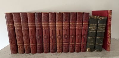 Plusieurs vieux livres sont alignés sur une étagère à côté d'un livre rouge