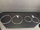 trois bracelets en argent posés sur une boîte noire