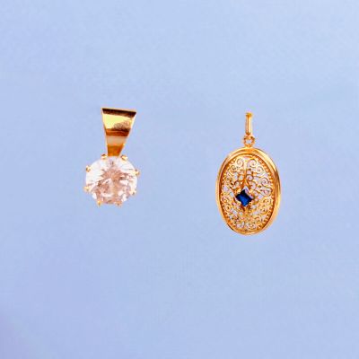 deux pendentifs en or sertis de diamants et d'une pierre bleue