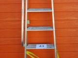 une échelle appuyée contre un mur rouge