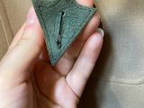 a person holding a piece of cloth with a pin in it