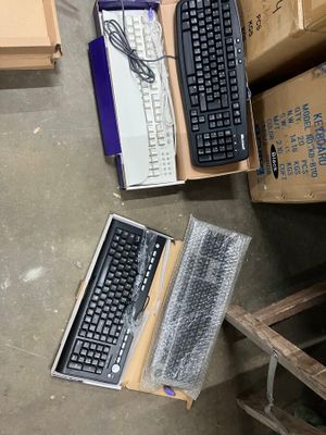 a computer keyboard and a laptop sitting on the floor