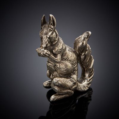a close up of a statue of a squirrel on a black surface