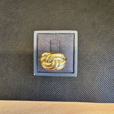 gros plan d'une bague en or sur une surface noire