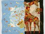 two pieces of fabric with a giraffe and birds on them
