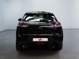 the rear end of a black car in a white room