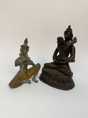 statue d'un homme assis sur un rocher, à côté d'une statue d'une femme assise sur un rocher