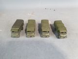 four toy army trucks lined up on a table