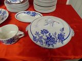 many plates and bowls on a table with a red table cloth