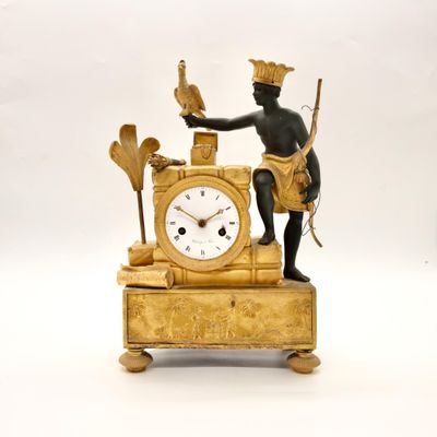 a gold clock with a man holding a bird on top of it