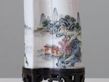 un vase avec un tableau posé sur une table