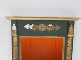 a green and gold fireplace with a red door