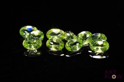 un groupe de perles en cristal vert posées sur une surface noire