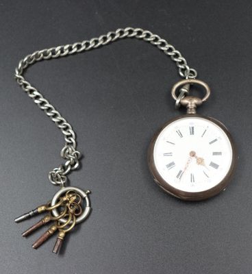 a silver pocket watch with a chain attached to it