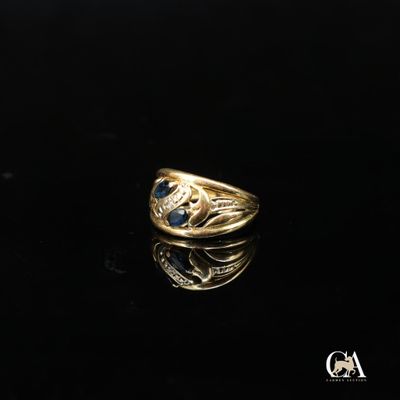 une image d'une bague en or avec une pierre bleue au centre