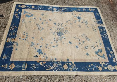 un tapis chinois ancien avec une bordure bleue et un motif floral