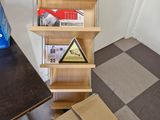 a cardboard box that is sitting on the floor next to a book shelf