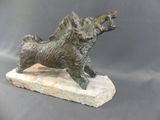 bronze statue of a dog on a rock on a gray background