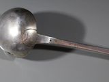 a silver spoon with a spoon handle on a table