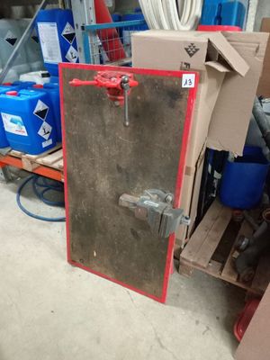une porte métallique avec une poignée rouge dans un entrepôt