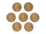 six types différents de pièces d'or sur une surface blanche