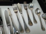 a lot of silver spoons and forks on the table