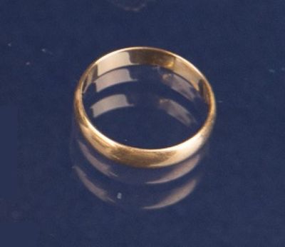 une bague en or posée sur une surface noire