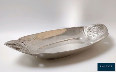 une image représentant une assiette en argent posée sur une surface blanche