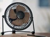 a small fan sitting on top of a wooden table