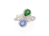 un gros plan d'une bague ornée d'une pierre verte, bleue et blanche