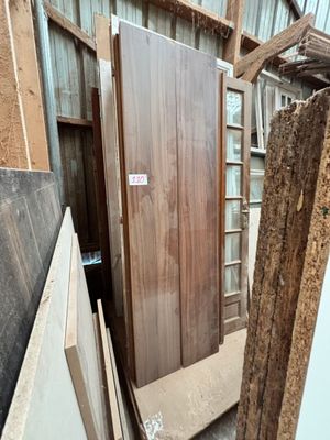 Plusieurs morceaux de bois sont empilés devant un bâtiment